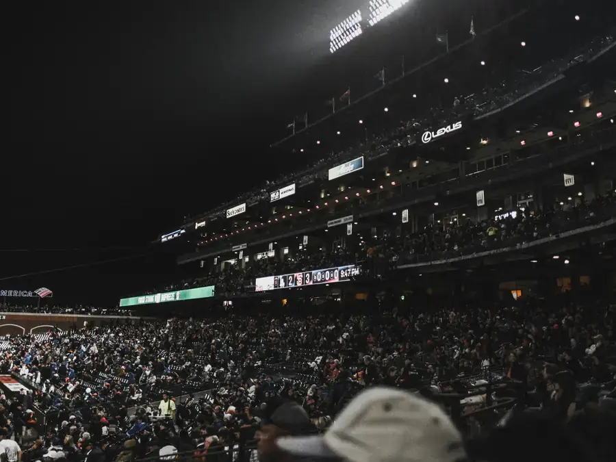 Packed football stadium under the lights at night