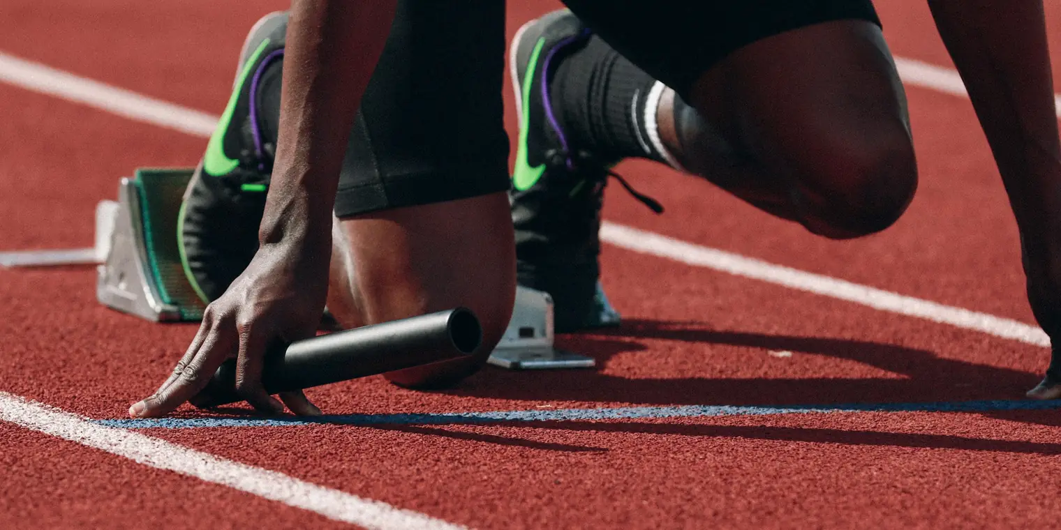 Sprinter set in the starting blocks on a red track, waiting for the gun