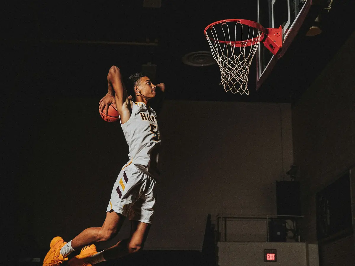 Sample photo of a high school basketball player rising for a dunk in an empty gym
